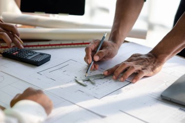 Architects and engineers are working together to edit the draft house plan that was designed after it was presented to the client and partially revised the design. Interior design and decoration ideas