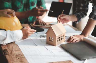 Architects and engineers are working together to edit the draft house plan that was designed after it was presented to the client and partially revised the design. Interior design and decoration ideas