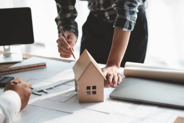 Architects and engineers are working together to edit the draft house plan that was designed after it was presented to the client and partially revised the design. Interior design and decoration ideas