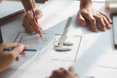 Architects and engineers are working together to edit the draft house plan that was designed after it was presented to the client and partially revised the design. Interior design and decoration ideas