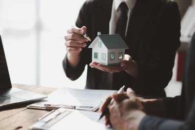 Ev satış temsilcileri ve satış temsilcileri projedeki evleri görmek isteyen müşterilere projede konut detaylarını tavsiye ediyorlar. Gayrimenkul ticareti.