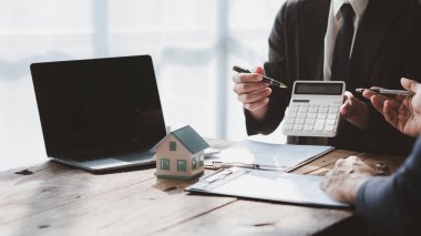 Ev satış temsilcileri ve satış temsilcileri projedeki evleri görmek isteyen müşterilere projede konut detaylarını tavsiye ediyorlar. Gayrimenkul ticareti.