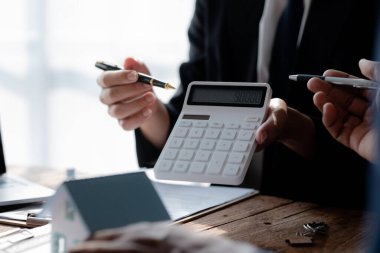 Ev satış temsilcileri ve satış temsilcileri projedeki evleri görmek isteyen müşterilere projede konut detaylarını tavsiye ediyorlar. Gayrimenkul ticareti.