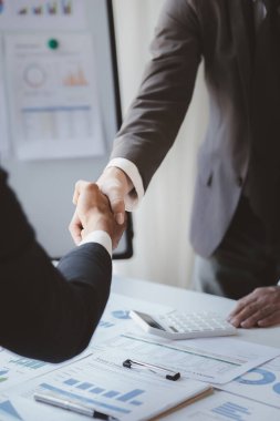 Yakın plan iki iş adamı el ele tutuşuyor, iki işadamı iş konusunda hemfikir ve başarılı bir pazarlıktan sonra el sıkışıyor. El sıkışmak Batının selamlaması ya da kutlamasıdır..