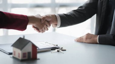 Konut kredisinin satış temsilcisi ve müşteri sözleşmeyi başarıyla imzaladıktan sonra el sıkışıyor. Konut ve gayrimenkul satma kavramı.