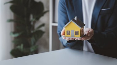 Konut kredisinin satış temsilcisi, sözleşmeye girecek olan müşterinin satış sözleşmesini hazırlıyor ve onaylıyor. Konut ve gayrimenkul satma kavramı.