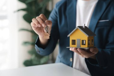 Konut kredisinin satış temsilcisi, sözleşmeye girecek olan müşterinin satış sözleşmesini hazırlıyor ve onaylıyor. Konut ve gayrimenkul satma kavramı.