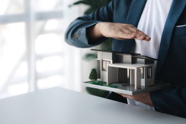 Konut kredisinin satış temsilcisi, sözleşmeye girecek olan müşterinin satış sözleşmesini hazırlıyor ve onaylıyor. Konut ve gayrimenkul satma kavramı.