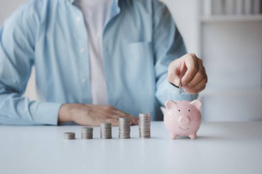 Person with pile of coins and piggy bank, money saving concept for future use and financial stability, salary management, personal finance, investment savings.