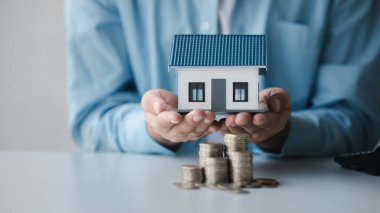 Person with stack of coins, saving money concept for future use and financial stability, savings for housing, payroll management, personal finance, investment savings.
