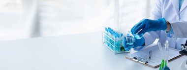 Laboratuvar asistanı, tıp bilimcisi, kimya araştırmacısı kan örneğinde cam bir tüp tutuyor, kimyasal bir deney yapıyor ve hastanın kan örneğini inceliyor. Tıp ve araştırma konsepti.