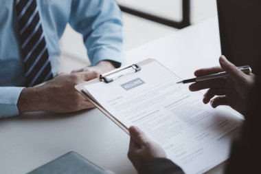 A person attends a job interview with a manager to join a company, he holds a resume and interview with information introducing himself and his ability to work. Job application concept.