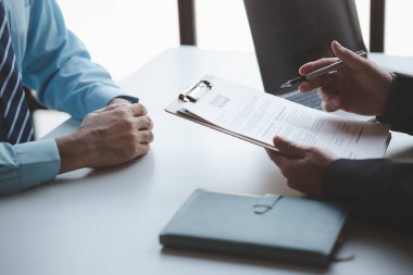 A person attends a job interview with a manager to join a company, he holds a resume and interview with information introducing himself and his ability to work. Job application concept.