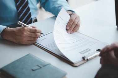 A person attends a job interview with a manager to join a company, he holds a resume and interview with information introducing himself and his ability to work. Job application concept.