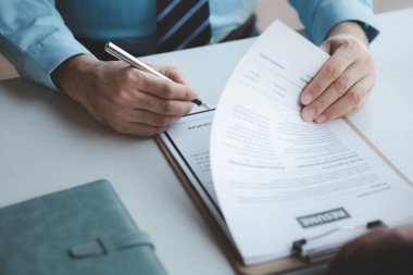 A person attends a job interview with a manager to join a company, he holds a resume and interview with information introducing himself and his ability to work. Job application concept.