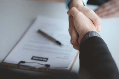 A person attends a job interview with a manager to join a company, he holds a resume and interview with information introducing himself and his ability to work. Job application concept.