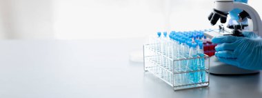 Lab practitioner working on chemical research for chemical reactions, does a chemical experiment and examines a patient's blood sample. Medicine and research concept.