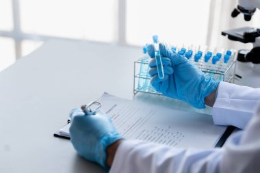 Lab practitioner working on chemical research for chemical reactions, does a chemical experiment and examines a patient's blood sample. Medicine and research concept.