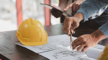 Architects and engineers are working together to edit the draft house plan that was designed after it was presented to the client and partially revised the design. Interior design and decoration ideas