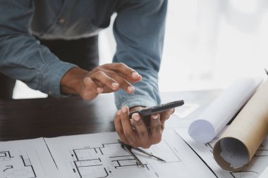 The home design architects are reviewing the house plan draft, the project commissioned by the client, and the custom design before delivery. Interior design and decoration ideas.