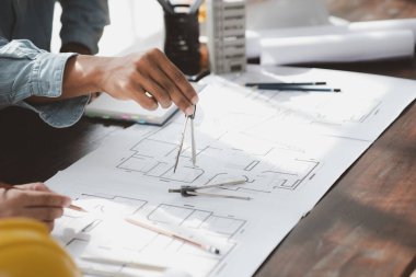 The home design architects are reviewing the house plan draft, the project commissioned by the client, and the custom design before delivery. Interior design and decoration ideas.