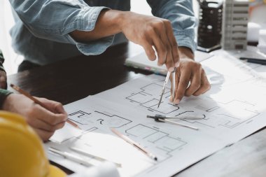 The home design architects are reviewing the house plan draft, the project commissioned by the client, and the custom design before delivery. Interior design and decoration ideas.