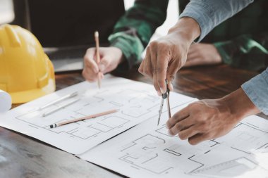 The home design architects are reviewing the house plan draft, the project commissioned by the client, and the custom design before delivery. Interior design and decoration ideas.