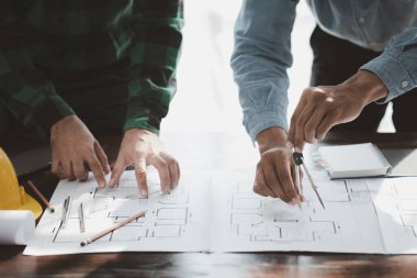 The home design architects are reviewing the house plan draft, the project commissioned by the client, and the custom design before delivery. Interior design and decoration ideas.