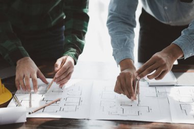 The home design architects are reviewing the house plan draft, the project commissioned by the client, and the custom design before delivery. Interior design and decoration ideas.