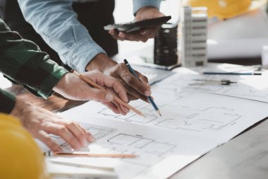 The home design architects are reviewing the house plan draft, the project commissioned by the client, and the custom design before delivery. Interior design and decoration ideas.