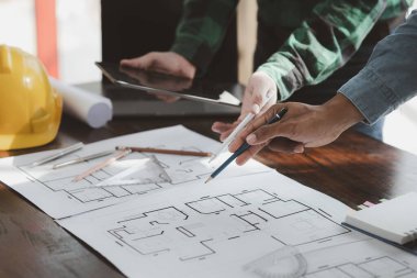 The home design architects are reviewing the house plan draft, the project commissioned by the client, and the custom design before delivery. Interior design and decoration ideas.