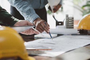 The home design architects are reviewing the house plan draft, the project commissioned by the client, and the custom design before delivery. Interior design and decoration ideas.