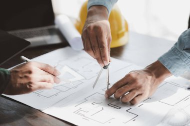 The home design architects are reviewing the house plan draft, the project commissioned by the client, and the custom design before delivery. Interior design and decoration ideas.