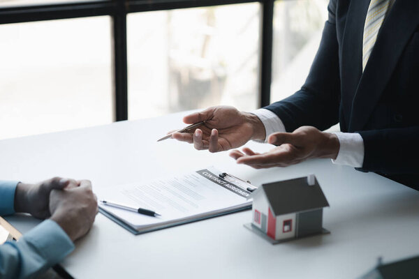 Real estate agents explain models of housing estates in projects to elaborate to clients, explaining and presenting information about homes and purchasing loans. Real estate trading concept.