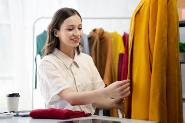 Beautiful girl clothing designer, the owner of the shop, she is the owner of a female fashion clothing store and designs clothes and cutting the dress by herself, selling products online.