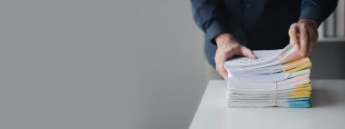 İş adamı, departman toplantı kağıtlarını düzenliyor, şirket ofisinde belge yönetimi yapıyor. Ofis belge yönetimi ve depolama kavramı.