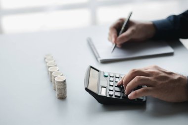 Bir işadamı gelirinin ve harcamalarının kaydını tutuyor, daha hızlı büyümesi için aylık tasarruflarını kullanarak para kazanmayı planlıyor. Yatırım için para biriktirme kavramı.