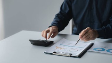 İşadamı, şirketin mali bilgilerini gösteren bir pasta grafiğine işaret ederek şirketin mali bilgilerini harita halinde gösteren özel ofisinde oturuyor. Finansal kavramlar