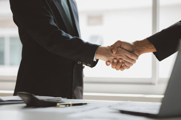 Business investor group holding hands, Two businessmen are agreeing on business together and shaking hands after a successful negotiation. Handshaking is a Western greeting or congratulation.