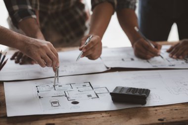 Architects and engineers are working together to edit the draft house plan that was designed after it was presented to the client and partially revised the design. Interior design and decoration ideas