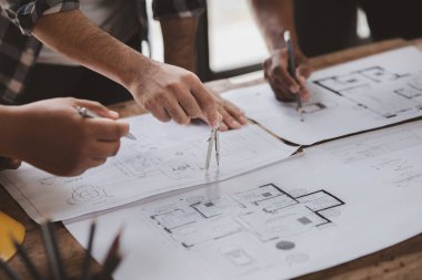 Architects and engineers are working together to edit the draft house plan that was designed after it was presented to the client and partially revised the design. Interior design and decoration ideas