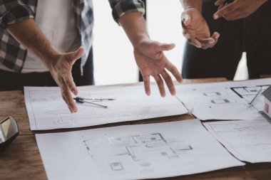 Architects and engineers are working together to edit the draft house plan that was designed after it was presented to the client and partially revised the design. Interior design and decoration ideas