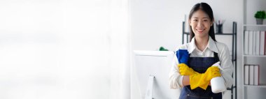 Ofisi temizleyen Asyalı kadın, temizlikçi. Örgüt içindeki temizliği koru. Ofis dezenfeksiyonu hastalık salgınlarını önler ve hijyeni korur.