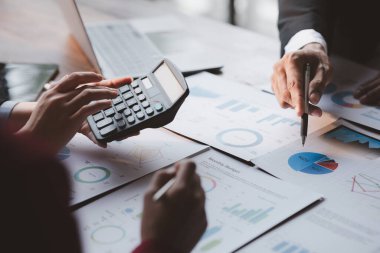 Grup iş adamları birlikte beyin fırtınası yapıyorlar ve finans departmanının özetlediği finansal belgeleri gözden geçiriyorlar. Onlar iş ortakları. İş yönetimi kavramı.