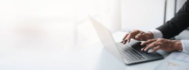 Laptop klavyesinde yazan kişi, dizüstü bilgisayarda çalışan iş adamı, iş arkadaşlarına mesaj yazıyor ve toplantıyı özetlemek için mali bilgi tablosu hazırlıyor..