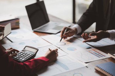 Grup iş adamları birlikte beyin fırtınası yapıyorlar ve finans departmanının özetlediği finansal belgeleri gözden geçiriyorlar. Onlar iş ortakları. İş yönetimi kavramı.