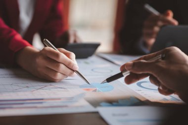 Grup iş adamları birlikte beyin fırtınası yapıyorlar ve finans departmanının özetlediği finansal belgeleri gözden geçiriyorlar. Onlar iş ortakları. İş yönetimi kavramı.