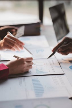 Grup iş adamları birlikte beyin fırtınası yapıyorlar ve finans departmanının özetlediği finansal belgeleri gözden geçiriyorlar. Onlar iş ortakları. İş yönetimi kavramı.