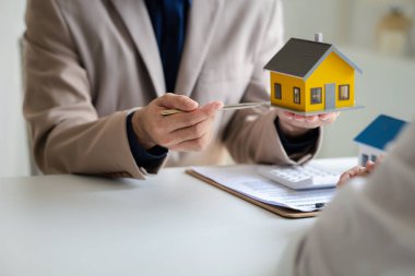 Emlakçılar, konut modellerini müşterilere ayrıntılı bir şekilde anlatma, evler ve satın alma kredileri hakkında bilgi verme ve sunma konularında açıklar. Gayrimenkul ticareti.