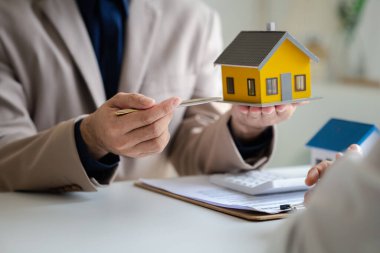 Emlakçılar, konut modellerini müşterilere ayrıntılı bir şekilde anlatma, evler ve satın alma kredileri hakkında bilgi verme ve sunma konularında açıklar. Gayrimenkul ticareti.